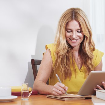 Smiling businesswoman writing in planner
